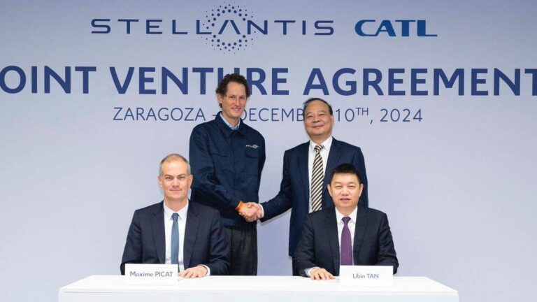 Se ven cuatro personas, dos de ellas sentadas y las otras dos de pie y dándose la mano. Detrás se lee "Stellantis CATL, Joint Venture Agreement, Zaragoza, December 10th 2024".
