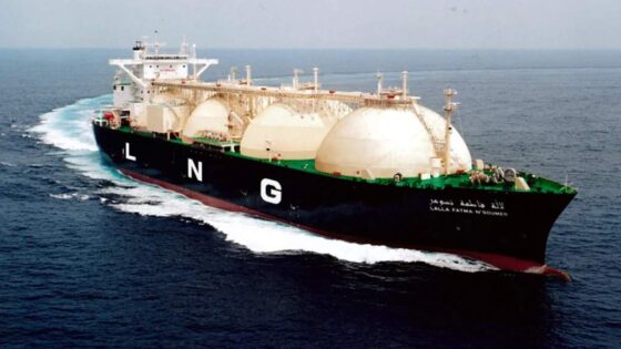 Se observa un buque metanero diseñado para el transporte de gas natural licuado (GNL). navegando sobre aguas tranquilas. Las letras "LNG" (siglas en inglés de gas natural licuado) son claramente visibles en su casco.
