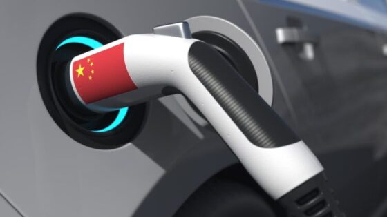 Imagen de una toma de alimentación de un vehículo eléctrico con una banderita china.