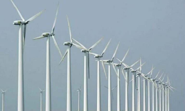 Una l?nea de molinos de energ?a e?lica con un fondo de un cielo celeste.