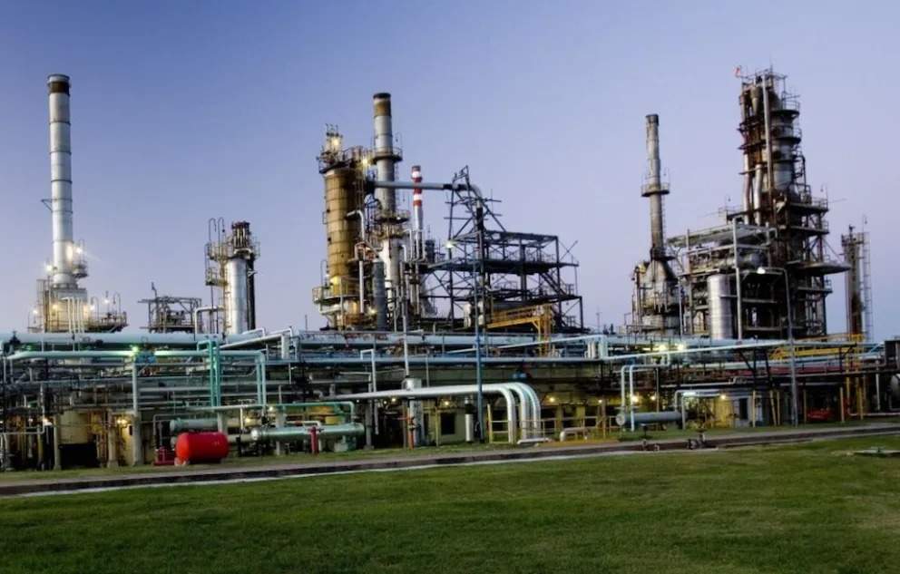 La imagen corresponde a una refiner?a de hidrocarburos con un cielo azul de fondo.