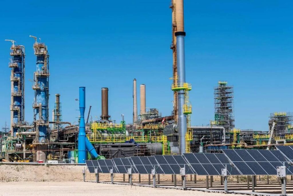 Imagen de una refiner?a recortada con un fondo de cielo azul.