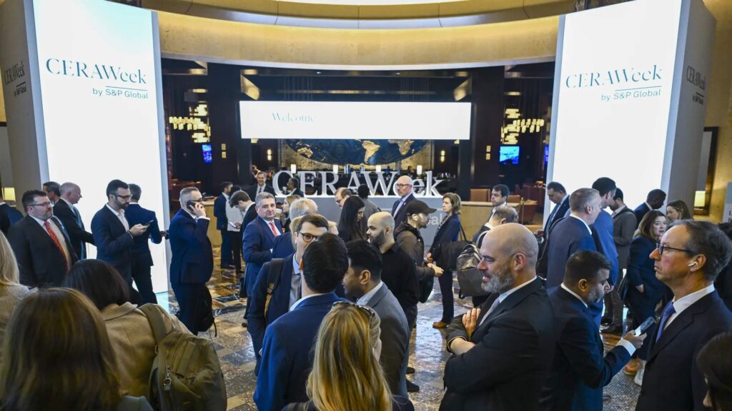 Una reuni?n de personas con tres logos de CERAWeek a los lados y al centro.