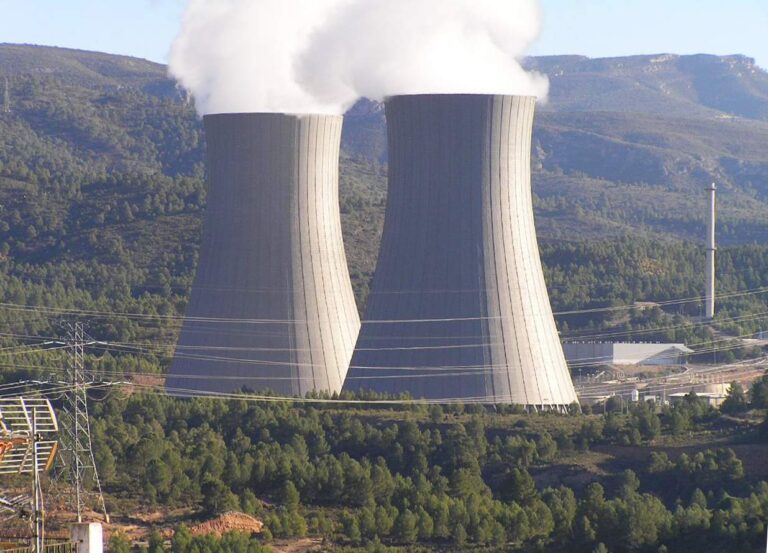 Torres de refrigeración de una central nuclear rodeadas de un paisaje monta?oso y boscoso. Las estructuras liberan vapor de agua al cielo.