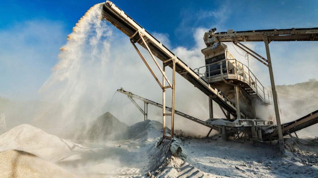 Planta de procesamiento de arena para fractura hidr?ulica (fracking), con cintas transportadoras arrojando material pulverizado. La imagen ilustra una etapa clave en la preparación de insumos para la extracción no convencional de hidrocarburos.