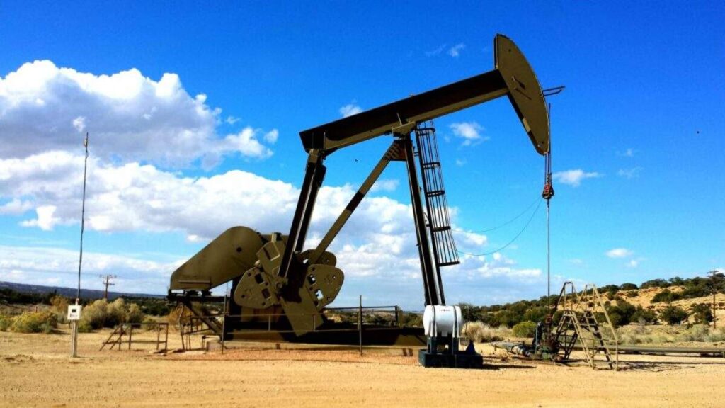 Bomba extractora de petróleo tipo balanc?n operando en un yacimiento terrestre bajo cielo despejado.