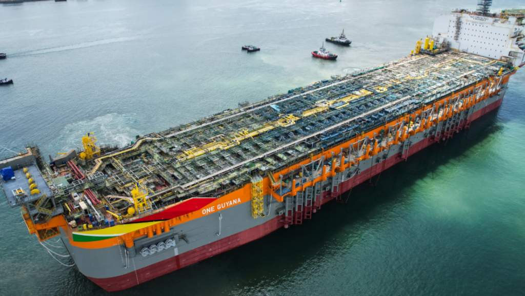 Plataforma flotante de producción de petróleo en el mar con embarcaciones de apoyo alrededor.