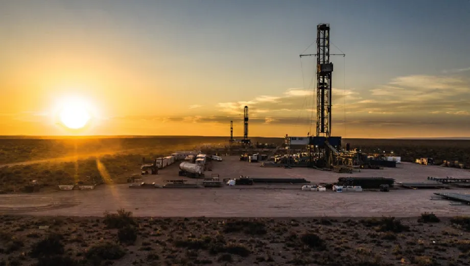 Plataforma de perforación petrolera en operación durante el atardecer en una zona des?rtica.