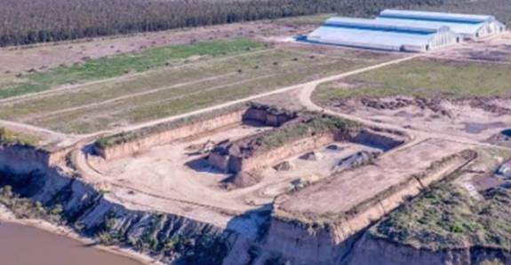 Vista aérea del predio en construcción de la empresa ACA junto al rño Paran?, con movimientos de suelo y galpones parcialmente terminados.