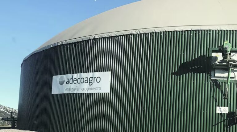 Instalación industrial de biogás con tanque cilíndrico de almacenamiento perteneciente a Adecoagro, bajo cielo despejado.