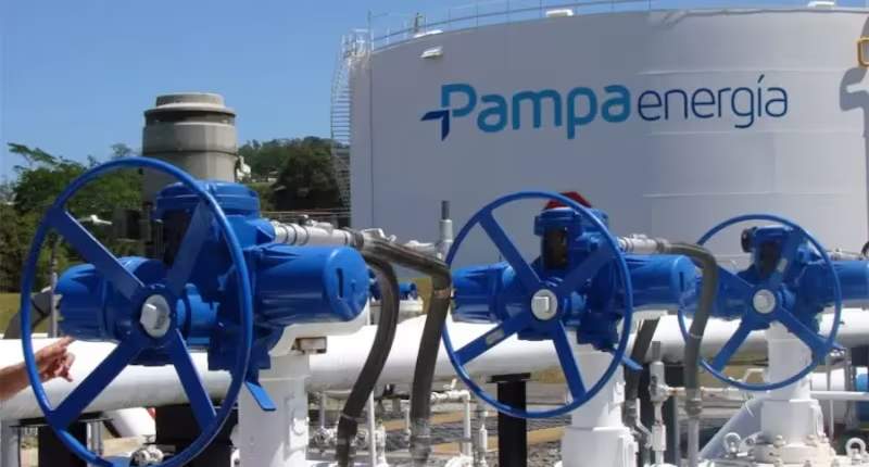 Válvulas industriales azules en una instalación energética, con un tanque de Pampa Energía al fondo.