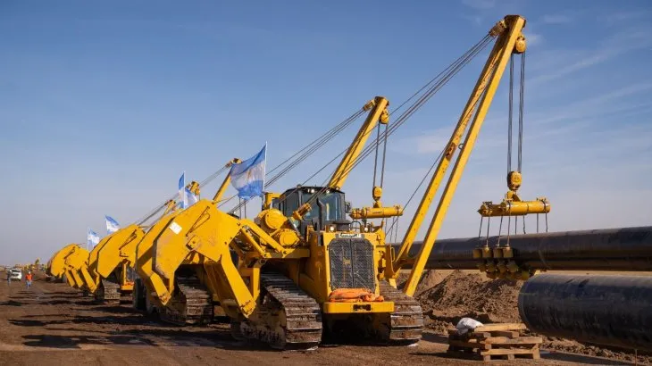 Maquinaria pesada instala un gasoducto con grandes tuberías de acero en una obra de infraestructura energética.