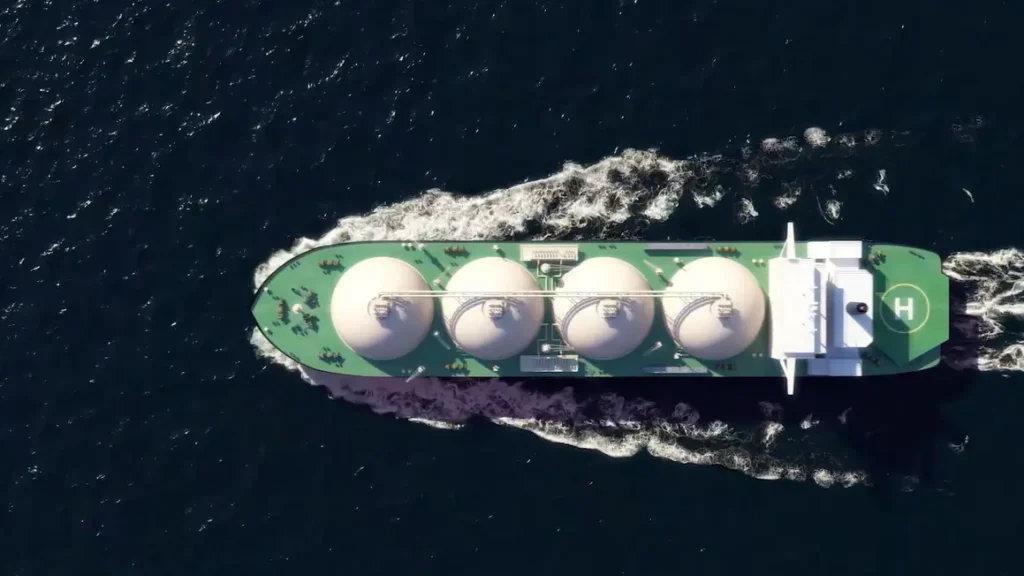 Vista aérea de un buque metanero navegando en mar abierto, equipado con grandes tanques esféricos para el transporte de gas natural licuado (GNL).