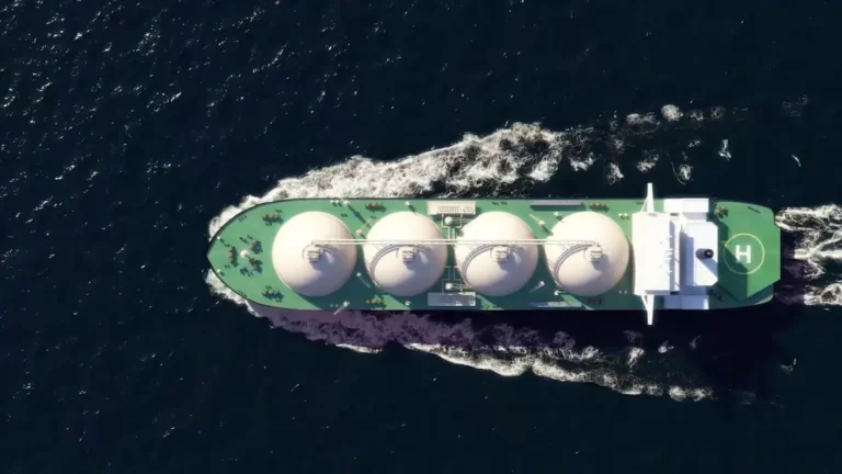 Vista aérea de un buque metanero navegando en mar abierto, equipado con grandes tanques esféricos para el transporte de gas natural licuado (GNL).